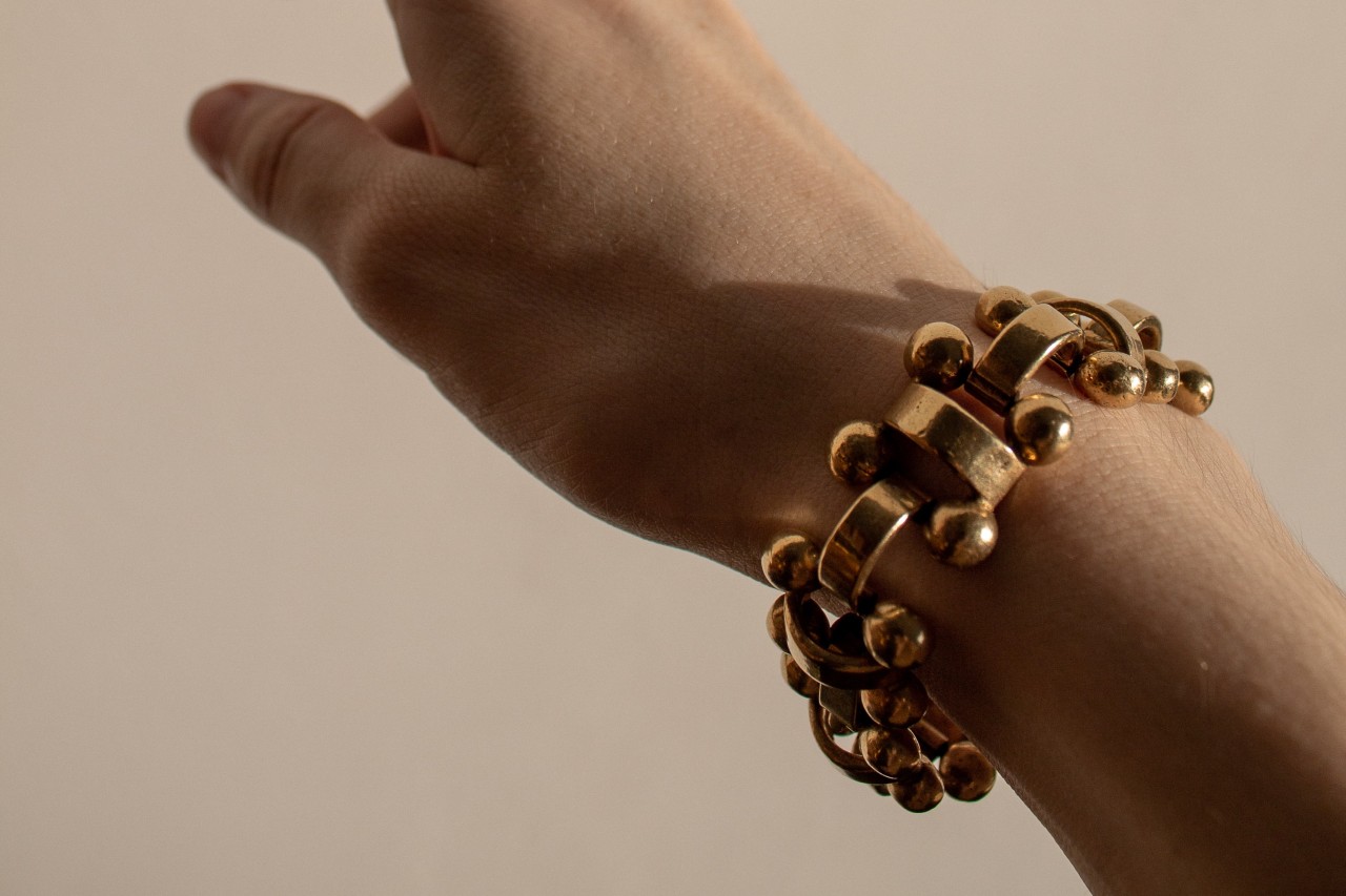 A woman wearing a gold elastic bracelet from Roberto Demeglio.
